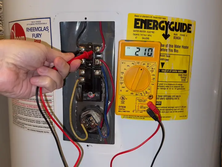 Electric water heater repair in Revere, MA using a multimeter on the upper thermostat