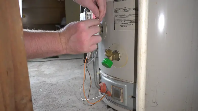 Technician performing water heater repair in Revere, MA on a gas control valve